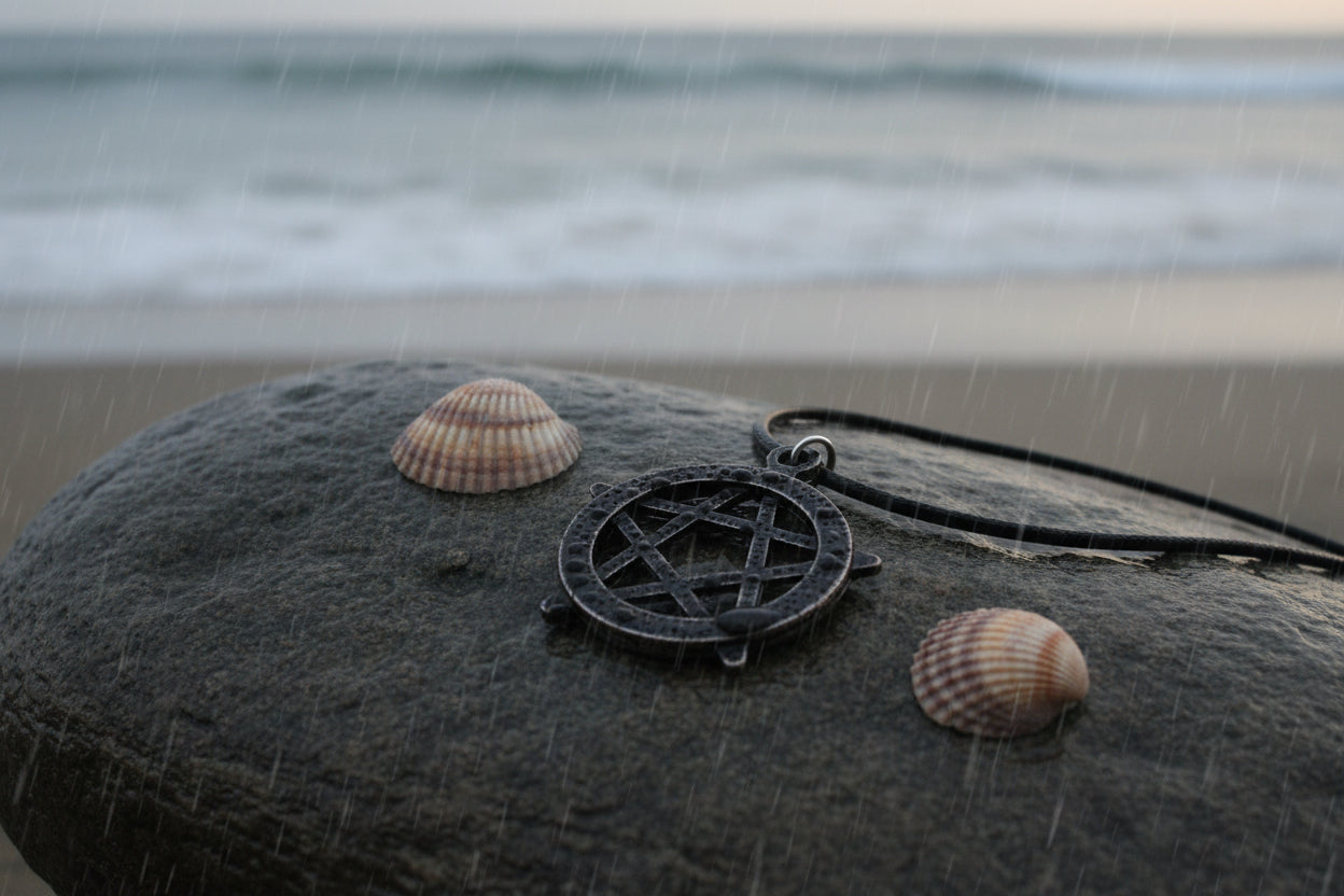 Silver pentacle pendant on a black cord with seashells in the background