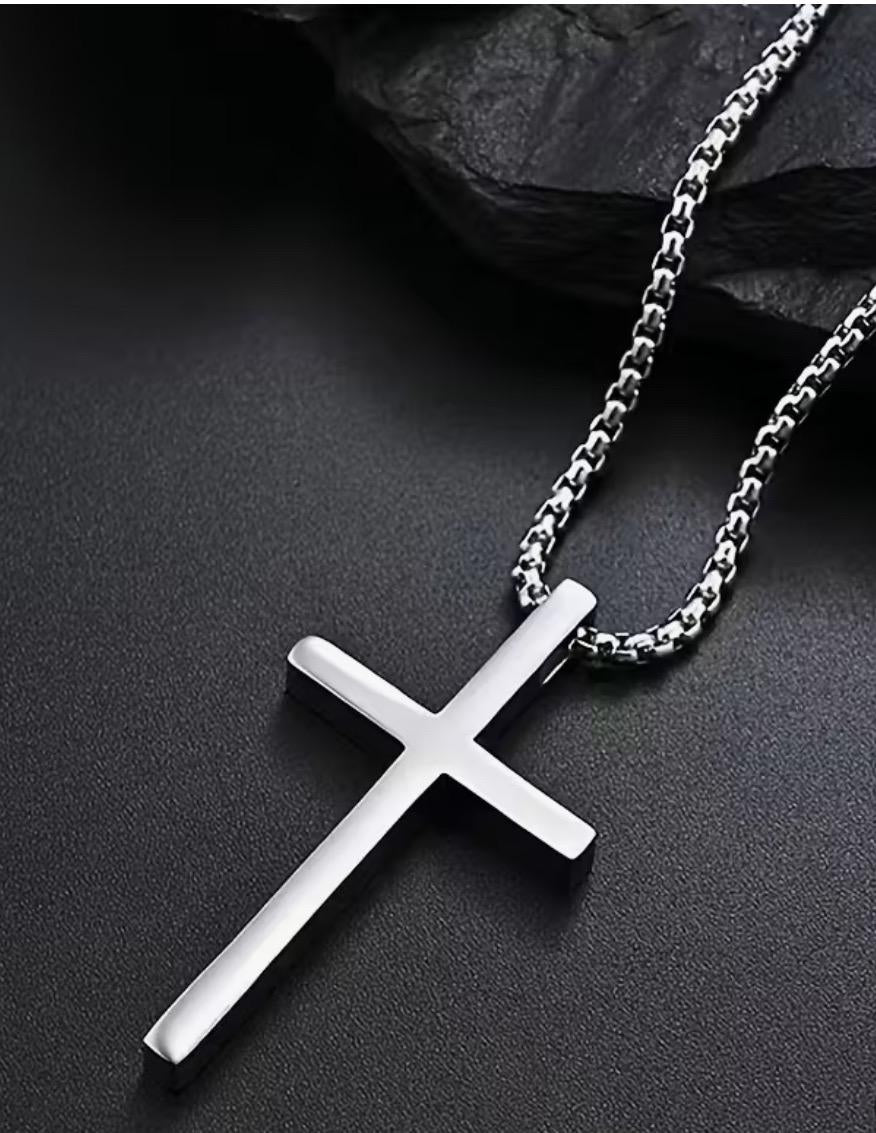 Silver cross necklace on a dark surface